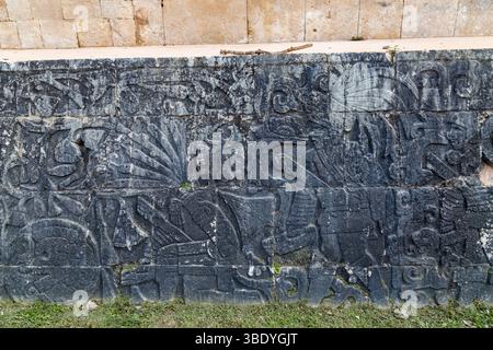 Chichen Itza, Mexiko - 25. Februar 2019: Gemeißelte Steinmauer mit Maya-Figuren, die ihre kulturelle und historische Bedeutung zeigen. Stockfoto
