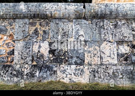 Chichen Itza, Mexiko - 25. Februar 2019: Gemeißelte Steinmauer in Chichen Itza, die die Kunst der Maya und die historische Bedeutung zeigt. Stockfoto