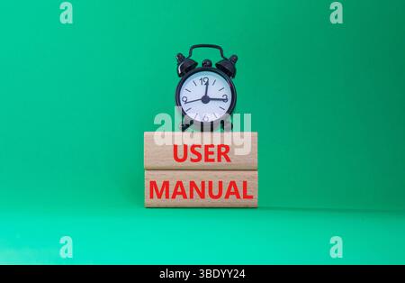 Symbol Benutzerhandbuch. Concept Words Benutzerhandbuch auf Holzblöcken. Schöner grüner Hintergrund mit Wecker. Konzept des Geschäfts- und Benutzerhandbuchs. Kopie sp Stockfoto