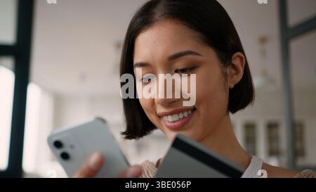 Glückliches lächelndes Käufermädchen hispanic Frau Frau weibliche Benutzer kaufen Konsumgüter online Shopping Zahlung zu Hause Smartphone Internet Bank App Pay Store Stockfoto
