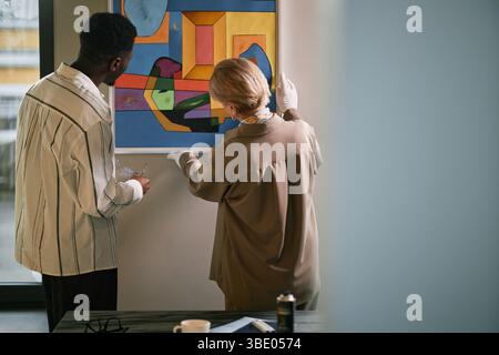 Moderne Kunstwerke in Galerie-Setting zusammen untersuchen Stockfoto