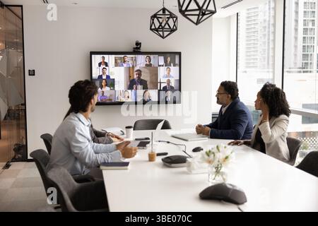 Gruppe von multiethnischen Fachleuten, die an virtuellen Treffen teilnehmen Stockfoto