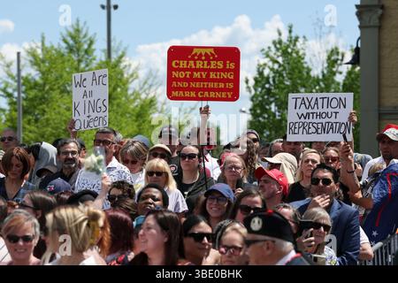 Die Demonstranten halten Protestzeichen, während die Menschen darauf warten, König Karl III. Und Königin Camilla bei einem Besuch einer Gemeindeveranstaltung im Lansdowne Park in Ottawa zu sehen, bei der das kulturelle Erbe und die Vielfalt Kanadas im Rahmen des königlichen zweitägigen Besuchs in Kanada vorgestellt werden. Bilddatum: Montag, 26. Mai 2025. Stockfoto
