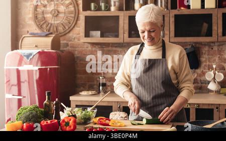 Fürsorgliche Großmutter Vorbereitung gesundes Mittagessen für die ganze Familie in der Küche Stockfoto