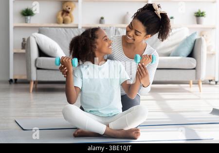 Liebevolle afroamerikanische Mutter und Tochter mit Langhanteln Stockfoto
