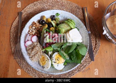 Frischer Salat mit Gemüse und Eiern auf Holztisch Stockfoto