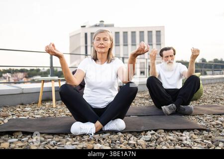 Seniorinnen und Senioren üben Yoga in urbaner Umgebung Stockfoto