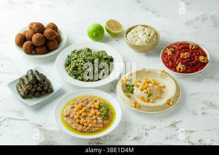 Arabische Mezze-Platte mit Foul, Hummus, Falafel, Muhammara, Auberginen-Dip, und Weinblätter Stockfoto