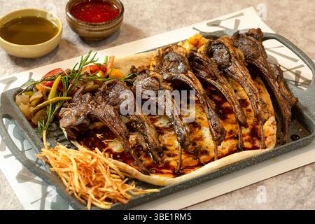 Gegrillte Lammrippchen mit Sauce, serviert als östliche arabische Spezialität Stockfoto