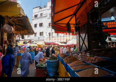 Geschäftiger Straßenmarkt in der Altstadt von Medina. Lebhafter Handel, reiche Auswahl an Waren, Fülle, volle Theken, Sonnenschirme für Verkäufer und Käufer. Casablanca. Stockfoto