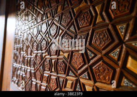 Islamischer Hintergrund. Islamisches Muster an der Holztür einer Moschee im Fokus. Stockfoto