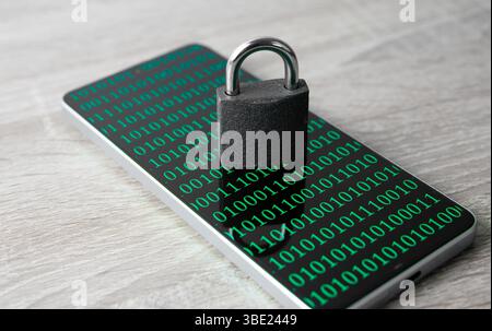 Ein Smartphone mit einem Bildschirm, auf dem Binärcode angezeigt wird, und einem geschlossenen Metallschloss. Ein Konzept der Internet- und Cybersicherheit. Stockfoto