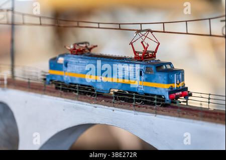 Miniatur-Elektrolokomotive, die Brücke überquert, Vintage-Spielzeugzug Stockfoto