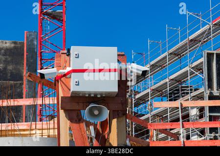 Auf einer Baustelle werden Überwachungskameras und ein Lautsprechersystem auf einer Holzhalterung aufgebaut. Stockfoto