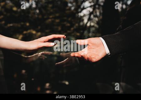 Hände, die Hand der Frau reicht zur Hand des Mannes. Ein Bild, das romantische Liebe, Bindung und Engagement ausdrückt. Stockfoto