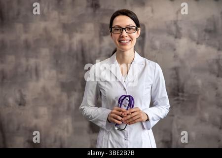 Lächelnde Ärztin im weißen Labormantel mit Stethoskop Stockfoto