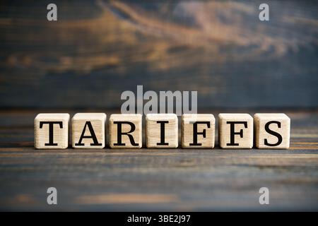 WORTTARIFE auf Holzblöcken vor rustikalem Holzhintergrund. Wirtschaftshandel, Finanzierungskonzept. Stockfoto