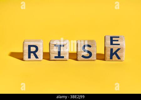 Holzblöcke, die Wörter bilden, können über gelben Hintergrund STEIGEN. Mut, Konsequenz Stockfoto