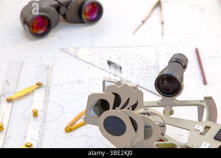 Navigationstools befinden sich auf der Navigationskarte. Sextant, Plotter, Teiler, Lineal und Fernglas. Stockfoto