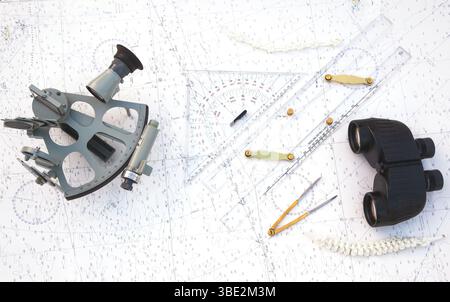 Navigationstools befinden sich auf der Navigationskarte. Sextant, Plotter, Teiler, Lineal und Fernglas. Stockfoto