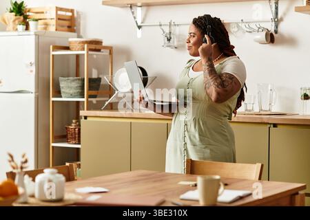 Eine junge Frau arbeitet in ihrem einladenden Küchenbereich aus der Ferne. Stockfoto