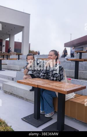 Frau und Mann ruhen auf Stufen, umgeben von sauberer geometrischer Stadtarchitektur. Stockfoto