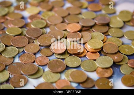 Verstreute Euro-Cent-Münzen in warmen Gold-Rot-Tönen - Stückelungen von 1, 2, 5 und 10 Cent - bilden einen reichen, strukturierten Hintergrund Stockfoto