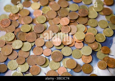 Verstreute Euro-Cent-Münzen in warmen Gold-Rot-Tönen - Stückelungen von 1, 2, 5 und 10 Cent - bilden einen reichen, strukturierten Hintergrund Stockfoto