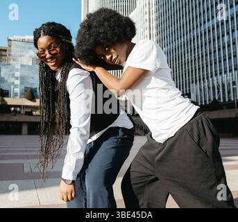 Afro-Frauen, die sich gegenseitig unterstützen und die Kamera in der Stadt betrachten Stockfoto