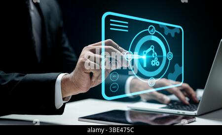 Geschäftsmann, der einen Laptop benutzt, während er einen Roboterarm und ein Gerätesymbol berührt. Tablette auf dem Tisch. Technologische Innovation auf einem virtuellen Bildschirm. Konzept von RO Stockfoto