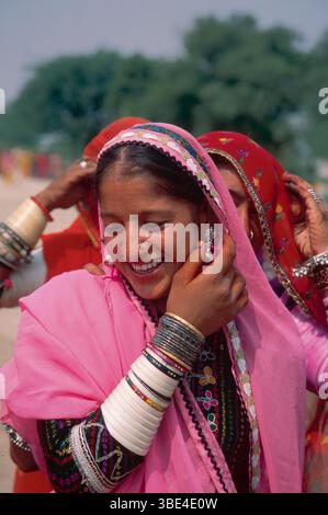 Lächelnde junge Frau in farbenfroher traditioneller Kleidung in Rajasthan, Indien Stockfoto