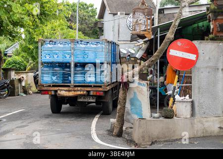 Bali, Indonesien - 28. Dezember 2024: Ein Lkw steht am Straßenrand mit einem großen Stapel blauer Wasserflaschen darauf Stockfoto