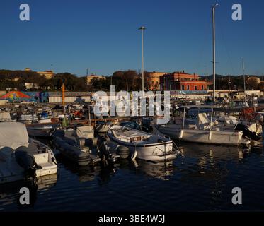 Sonnenuntergang am Ardenza Pier, Livorno – Boote im goldenen Licht Stockfoto
