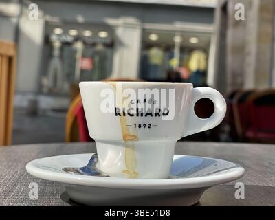 Kaffeetasse aus weißem Porzellan mit „CAFÉS RICHARD 1928“-Logo auf einer Untertasse, die den zeitlosen Charme der französischen Café-Kultur widerspiegelt Stockfoto
