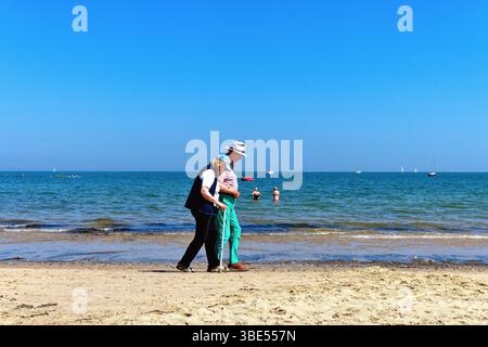Ein älteres Ehepaar, das an einem heißen Sommertag am Strand von Studland entlang spaziert, Dorset England UK Stockfoto