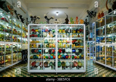 Eine lebendige Ausstellung von Steinkugeln und geschnitzten Edelsteinfiguren in einer Glasvorführung in einem dekorativen Steinladen in Danang, Vietnam Stockfoto