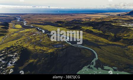 Weite Luftaufnahme von geflochtenen Flüssen, die durch moosiges und vulkanisches Gelände im Süden Islands fließen, mit Schmelzwasser von Gletschern, die sich über die Vas winden Stockfoto