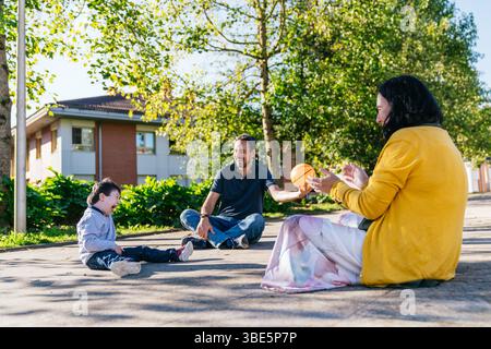 Eine fröhliche Familie verbringt einen verspielten Moment im Freien. Die Szene fängt Glück, Lachen und Verbundenheit ein, während sie die Gesellschaft des anderen im genießen Stockfoto