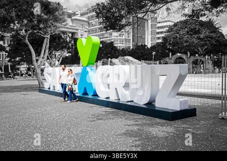 Ein Paar posiert vor dem „Santa Cruz“-Schriftzeichen und den Herzen auf der Plaza de España, Santa Cruz de Tenerife, Teneriffa, Spanien Stockfoto