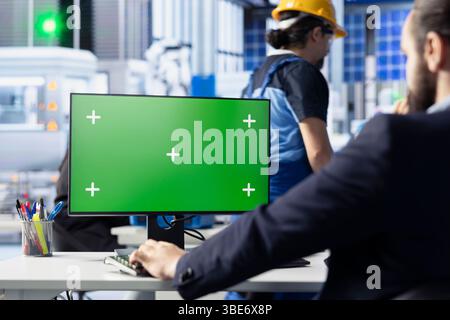 Ingenieur in der Photovoltaik-Fabrik überprüft Systemprotokolle auf dem Green-Screen-Computer, um betriebliche Ineffizienzen zu identifizieren. Photovoltaik-Anlagenarbeiter, der Fertigungsparameter auf Chroma Key PC anpasst Stockfoto