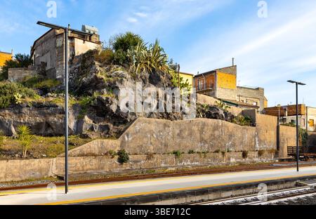 Bronte, Sizilien, Italien - 17. Februar 2023: Vulkanische Felsen mischen sich mit Stadtarchitektur in Bronte über dem Tal des Flusses Simeto am Westhang des Mount E. Stockfoto