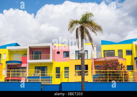 Farbenfrohes modernes Wohngebäude und Palme fotografiert im Hafen von Albufeira, Algarve Küste von Portugal Stockfoto