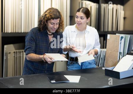 Ehemann und Ehefrau wählen Keramikfliesen für die Küchenverkleidung im neuen Haus Stockfoto