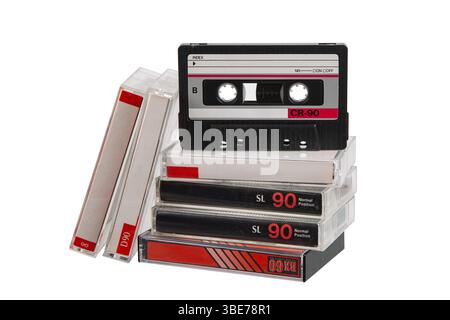 Stapel von Retro-Audiokassetten mit einer aufrecht positionierten Kassette, isoliert auf weißem Hintergrund. Stockfoto