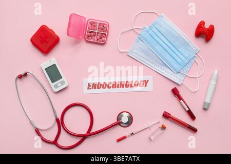 WORTENDOKRINOLOGIE mit medizinischem Zubehör auf rosa Hintergrund Stockfoto