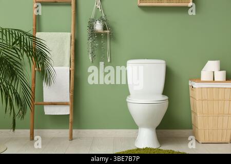 Das Innere des stilvollen Toiletten mit Keramikschale, Papierrollen und Korb Stockfoto