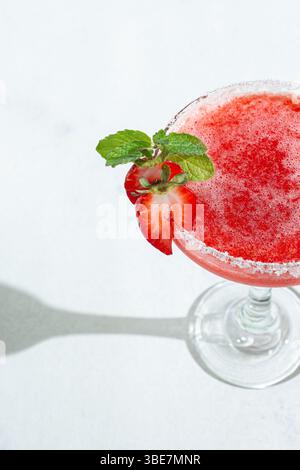 Close-up erfrischender Erdbeere-Daiquiri-Cocktail garniert mit Mint in heller Beleuchtung Stockfoto