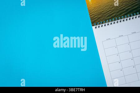 Kalenderseite auf blauem Hintergrund. Draufsicht und Kopierbereich. Stockfoto