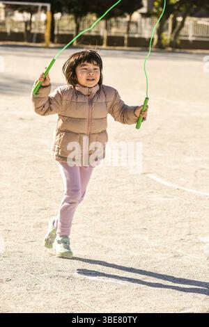 Kleinkind spielt Sprungseil Stockfoto