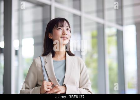Japanische Geschäftsfrau geht aus dem Büro Stockfoto
